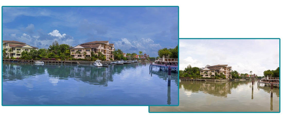 Waterfront canal with pastel houses, boats docked along the edge and calm reflective water under a blue sky.