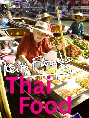 TV show cover: market vendors preparing Thai dishes; foreground man in a red shirt, smiling, beside a display of street food; bold pink text reads 'Thai Food' with 'Keith Floyd's'